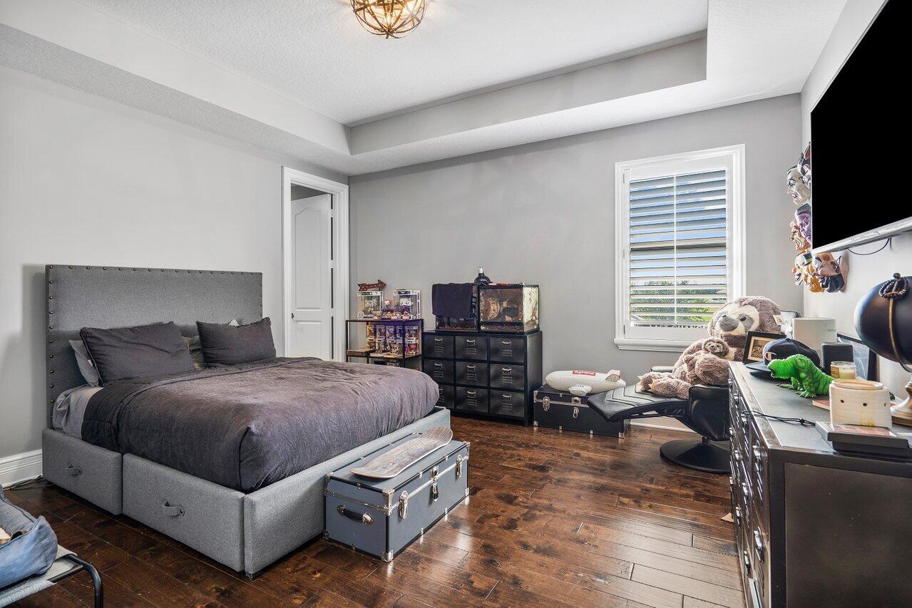 9891 Equus Circle Boynton Beach, FL 33472 - Photo 35 of 88 a bedroom with a bed a couch and a flat tv screen on dresser