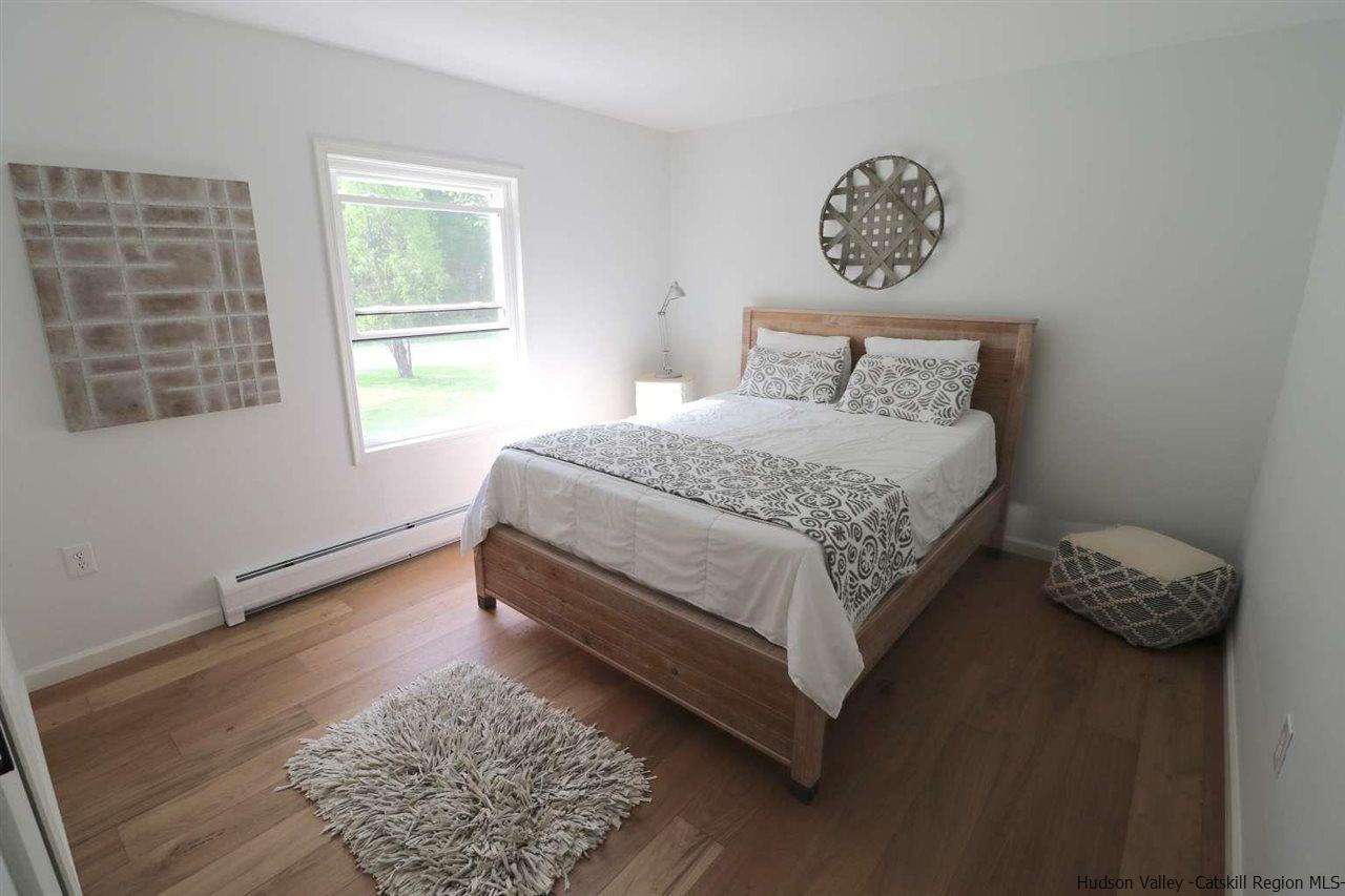 349 Co Road, Unit KRUMVILLE DAVIS CORNER RD Olivebridge, NY 12461 - Photo 13 of 25 a bed sitting in a bedroom next to a window