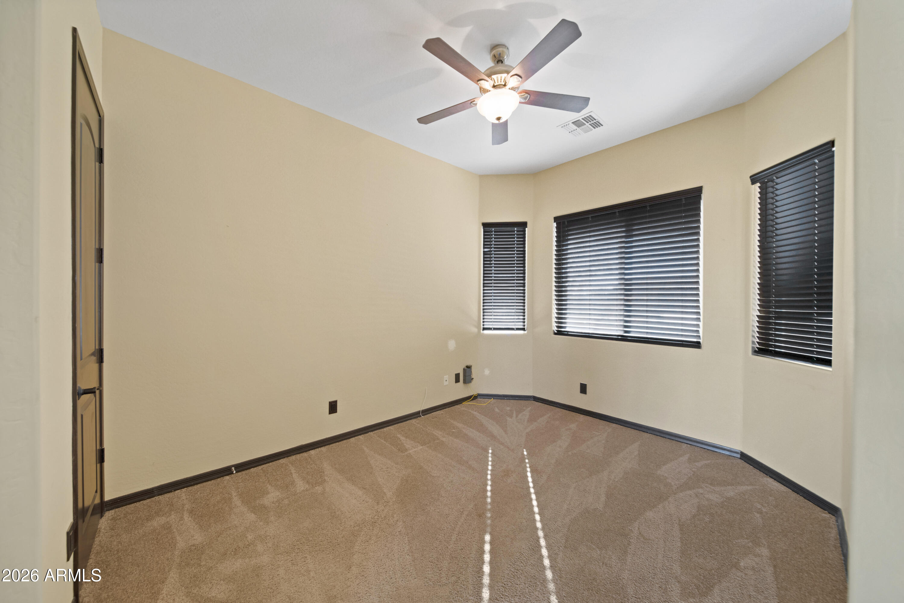 28621 North Bush Street Wittmann, AZ 85361 - Photo 18 of 41 an empty room with windows and ceiling fan