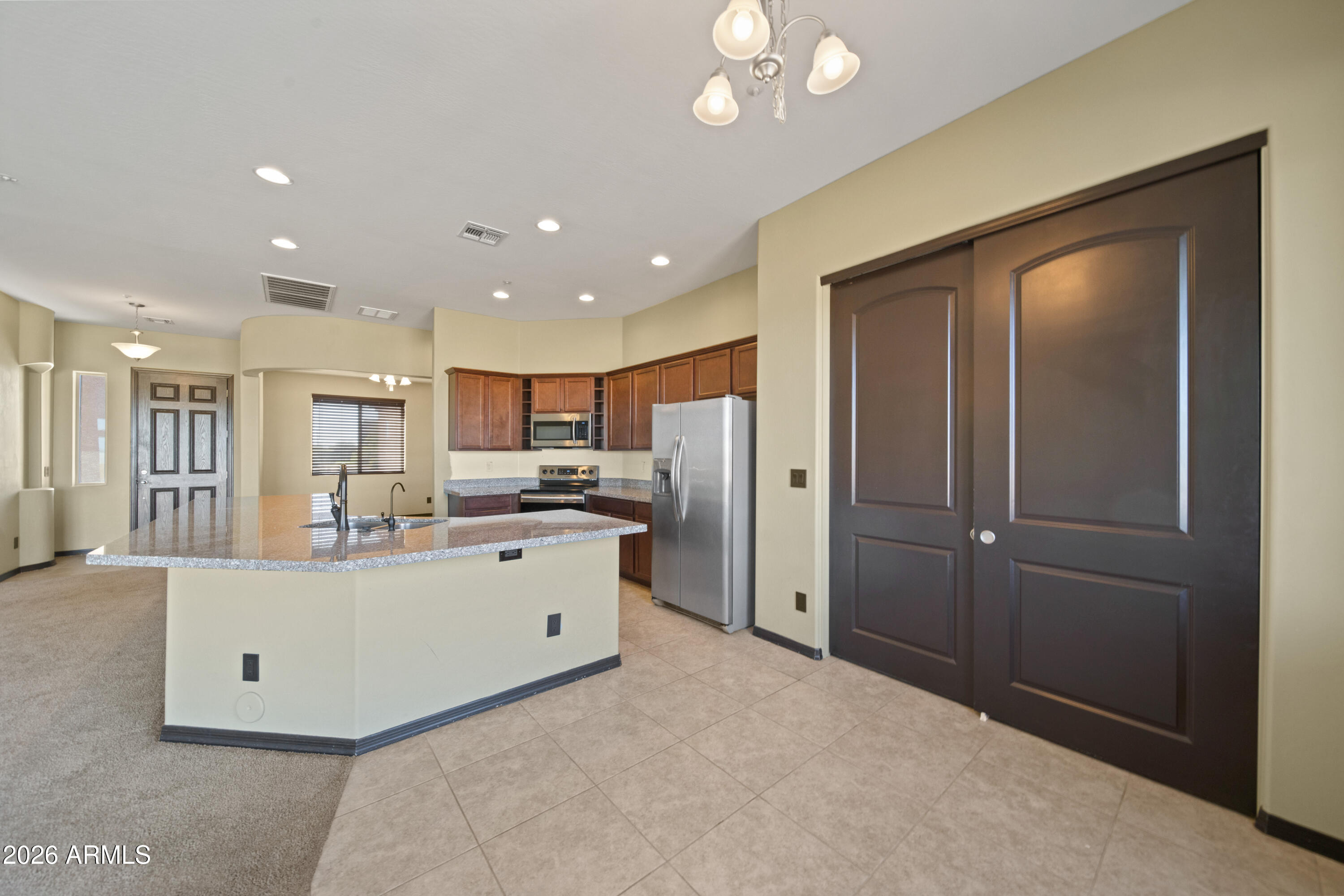 28621 North Bush Street Wittmann, AZ 85361 - Photo 23 of 41 a view of a kitchen with kitchen island stainless steel appliances refrigerator stove microwave and cabinets