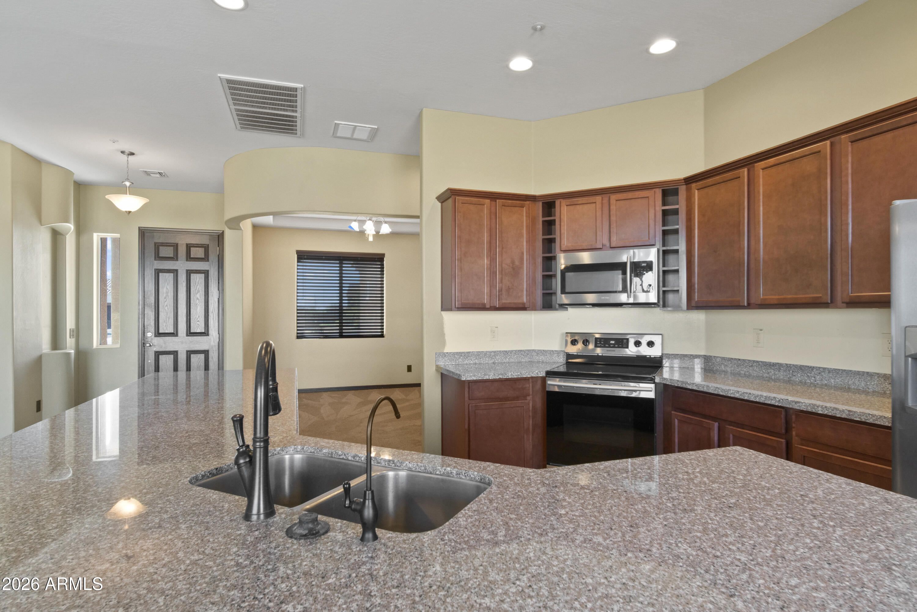 28621 North Bush Street Wittmann, AZ 85361 - Photo 25 of 41 a kitchen with stainless steel appliances granite countertop a sink stove and refrigerator