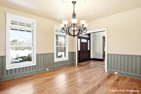 a view of a living room with chandelier and wooden floor