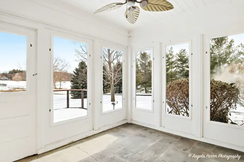 a view of an empty room with a fireplace and a ceiling fan