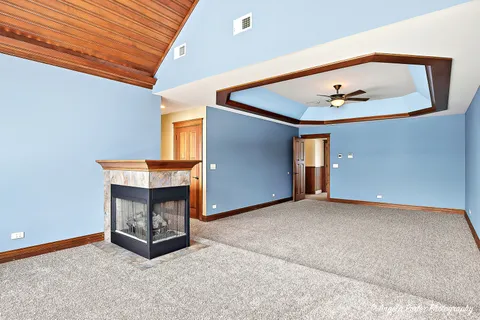 a view of spacious bedroom with a window and a ceiling fan