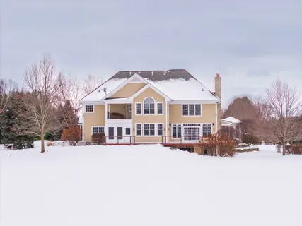 a view of a white house with a yard covered in snow