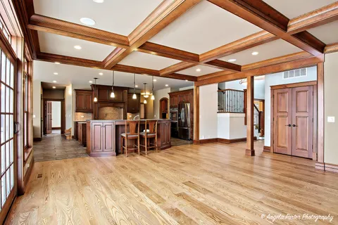 a kitchen with a stove a sink dishwasher and a refrigerator with wooden floor