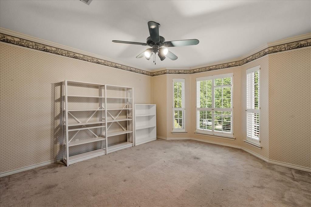 9 Willow Ridge Road Greenville, TX 75402 - Photo 21 of 31 Empty room with wallpapered walls, ornamental molding, carpet flooring, and a ceiling fan