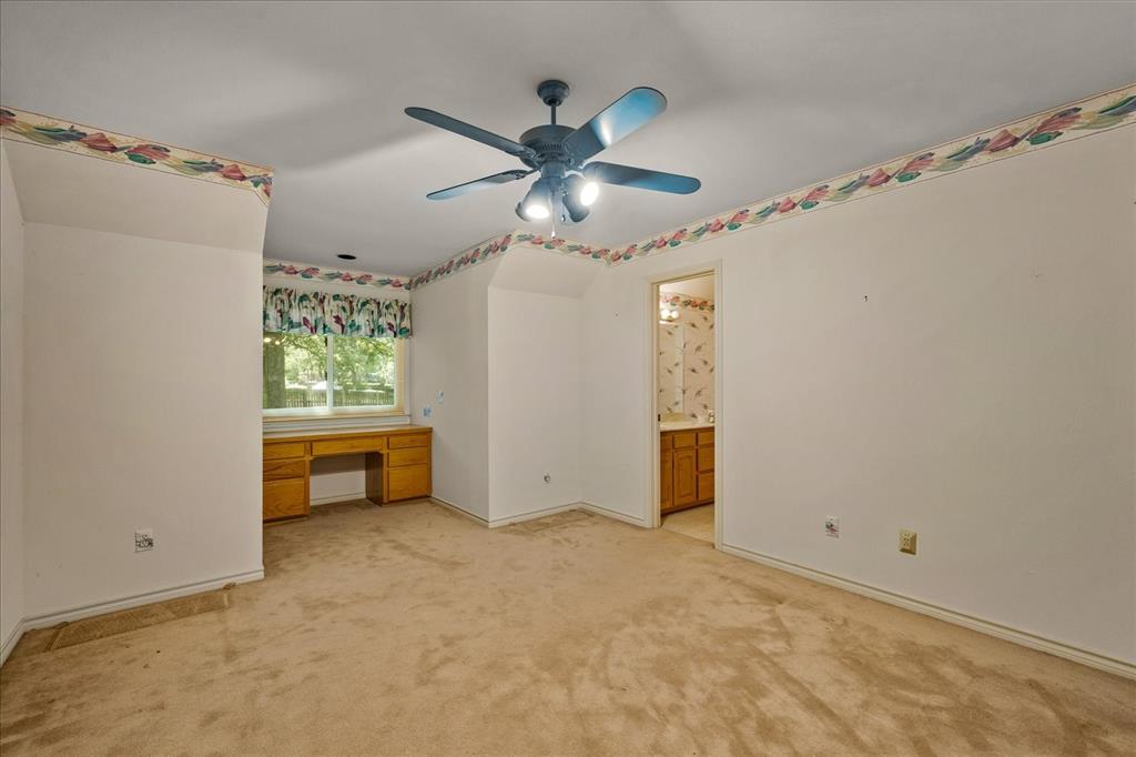 9 Willow Ridge Road Greenville, TX 75402 - Photo 22 of 31 Unfurnished bedroom featuring built in desk, light carpet, a ceiling fan, and connected bathroom