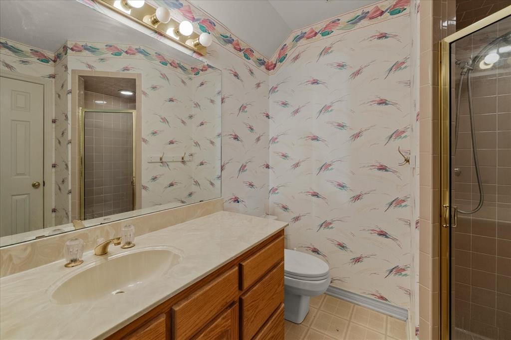 9 Willow Ridge Road Greenville, TX 75402 - Photo 23 of 31 Bathroom featuring vanity, wallpapered walls, a shower stall, and light tile patterned floors