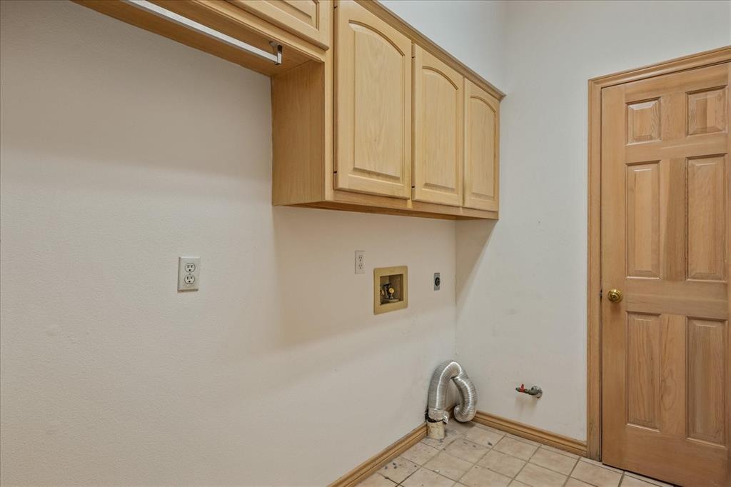 9 Willow Ridge Road Greenville, TX 75402 - Photo 25 of 31 Laundry area with cabinet space, gas dryer hookup, hookup for a washing machine, hookup for an electric dryer, and light tile patterned floors