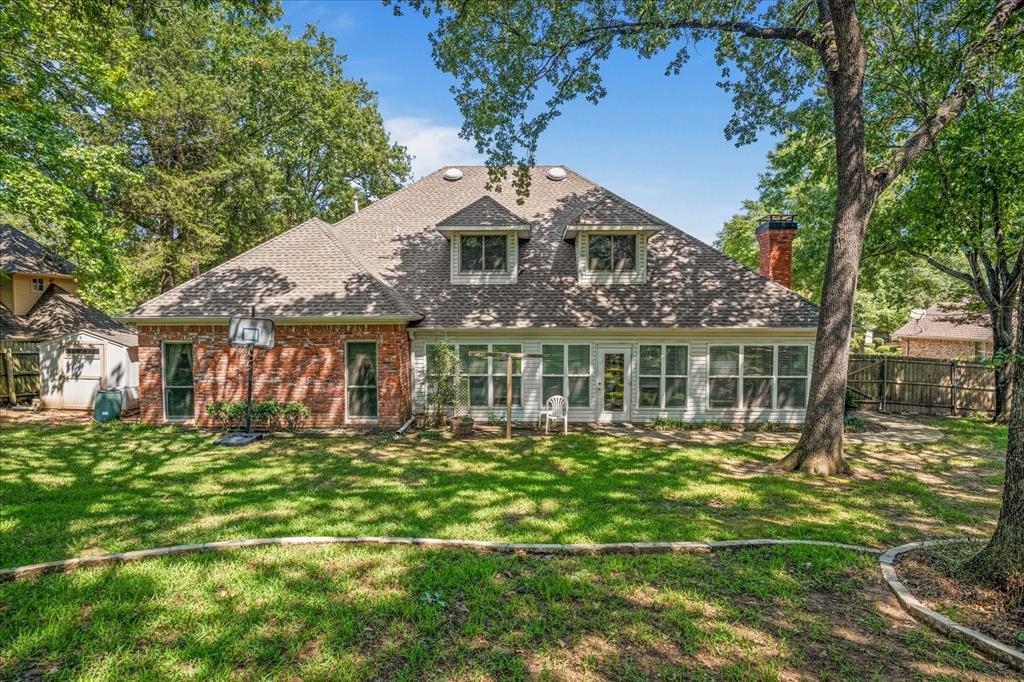 9 Willow Ridge Road Greenville, TX 75402 - Photo 26 of 31 View of front facade with brick siding, a chimney, a shingled roof, and a sunroom