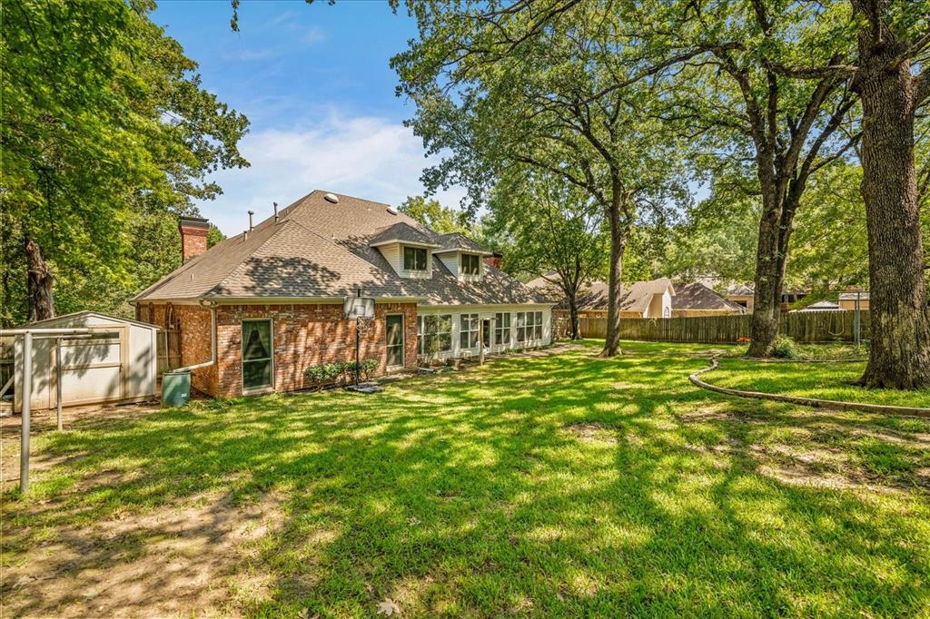 9 Willow Ridge Road Greenville, TX 75402 - Photo 28 of 31 Rear view of property featuring a storage shed, brick siding, a chimney, and a shingled roof