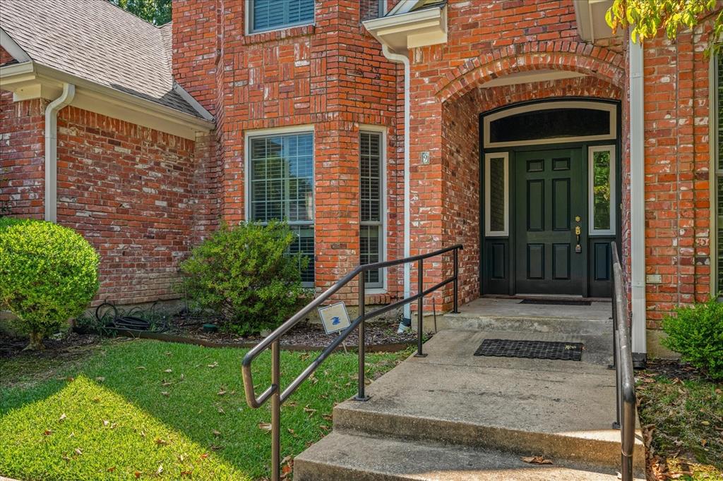 9 Willow Ridge Road Greenville, TX 75402 - Photo 3 of 31 View of exterior entry with brick siding, a shingled roof, and a lawn