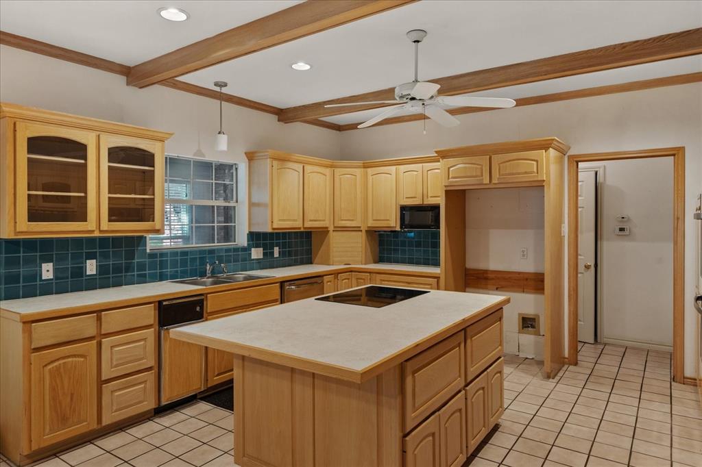 9 Willow Ridge Road Greenville, TX 75402 - Photo 9 of 31 Kitchen featuring light tile patterned floors, tasteful backsplash, glass insert cabinets, beamed ceiling, and a kitchen island