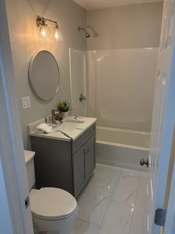 a bathroom with a toilet a sink and mirror