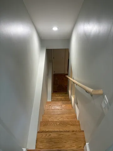 a view of a hallway with wooden floor and staircase