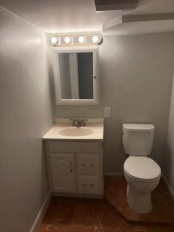a bathroom with a toilet sink and mirror