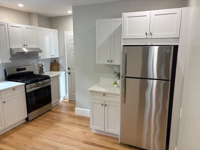 a kitchen with white cabinets and stainless steel appliances