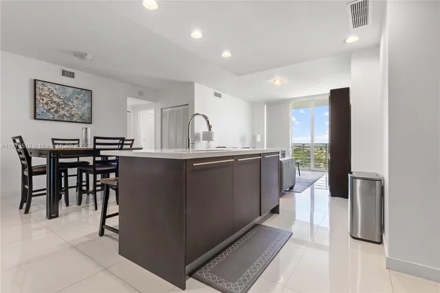 a kitchen with kitchen island granite countertop wooden cabinets a counter top space and stainless steel appliances