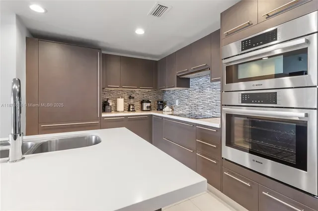 a kitchen with stainless steel appliances kitchen island granite countertop a stove microwave and sink