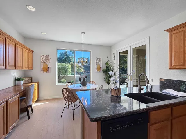 a kitchen with granite countertop a sink and white cabinets