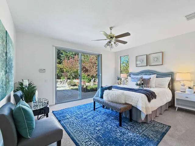 a bed sitting in a spacious bedroom next to a window