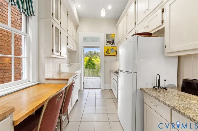 a room with stainless steel appliances kitchen island granite countertop furniture and a potted plant