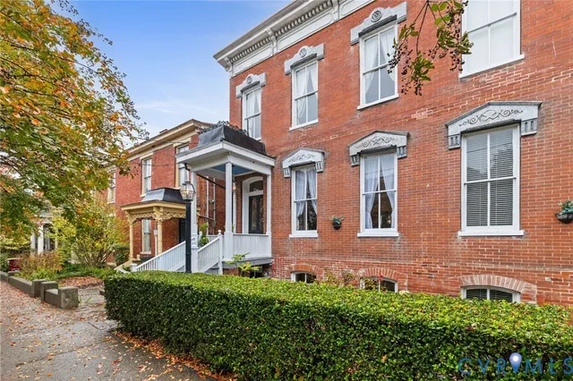 front view of a brick house with a small yard