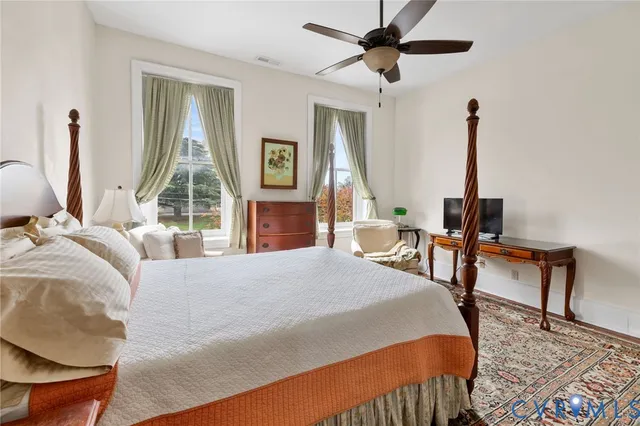 a bedroom with bed and paintings on the wall