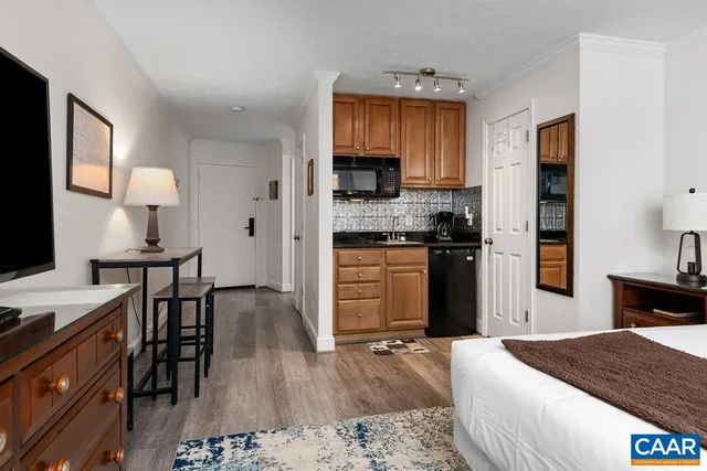 a kitchen with stainless steel appliances granite countertop a stove top oven a sink dishwasher and cabinets with wooden floor