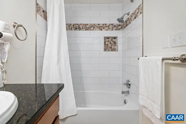a bathroom with a granite countertop sink a toilet and bathtub
