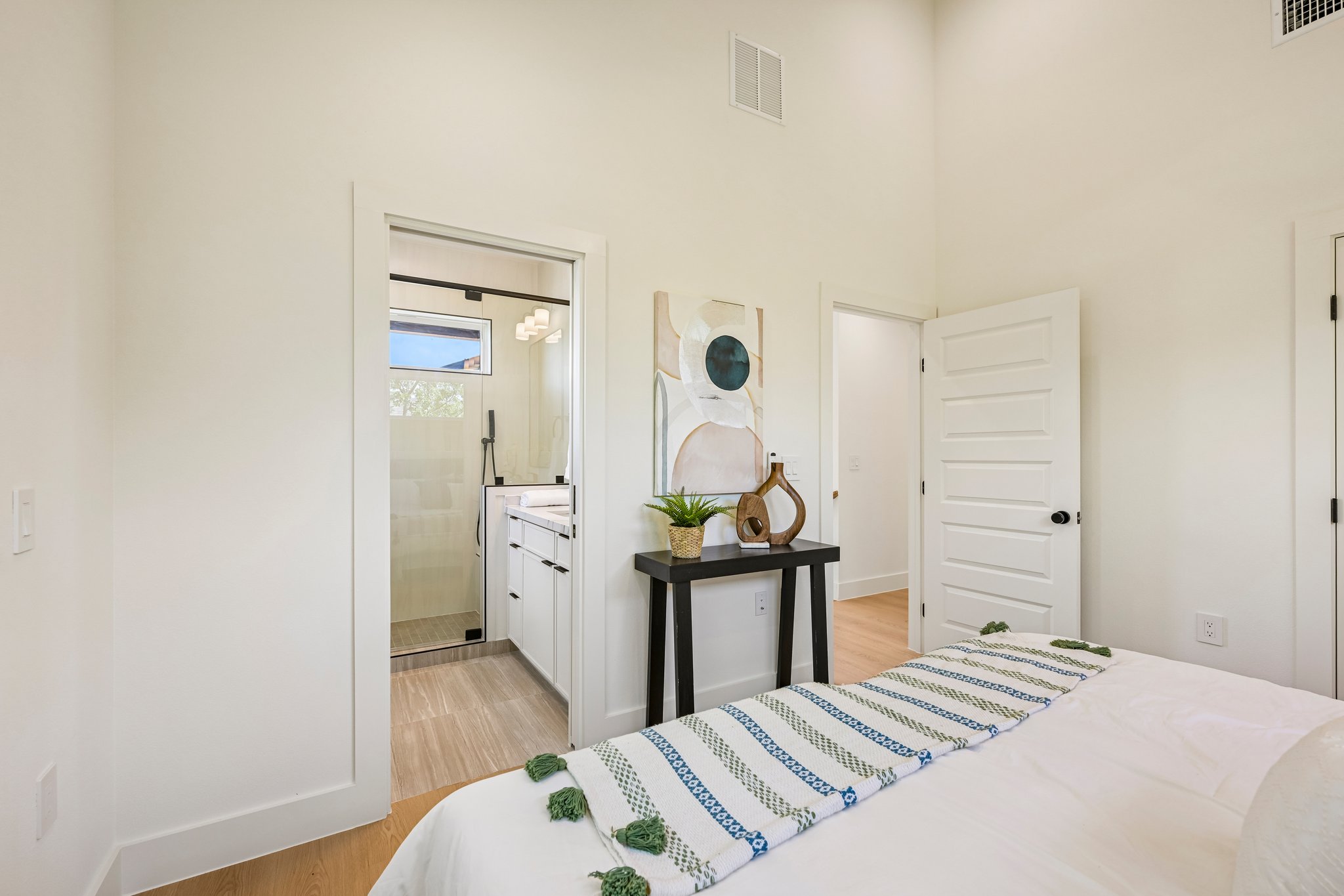 513 West Odell Street, Unit B Austin, TX 78752 - Photo 17 of 38 Well-lit bedroom with rich flooring and a functional en-suite bathroom.