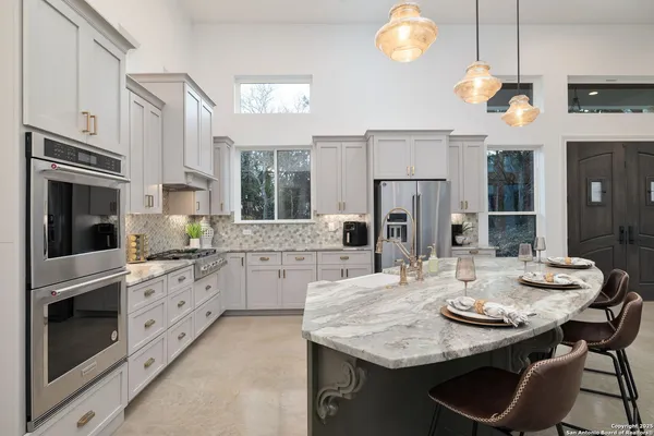 a kitchen with granite countertop white cabinets white stainless steel appliances with a sink and dishwasher