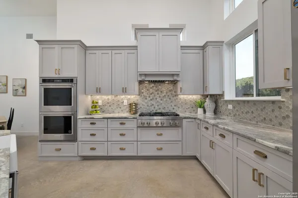 a kitchen with stainless steel appliances granite countertop a stove and a fireplace with wooden floor