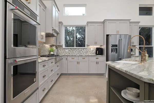 a kitchen with cabinets appliances and a chandelier