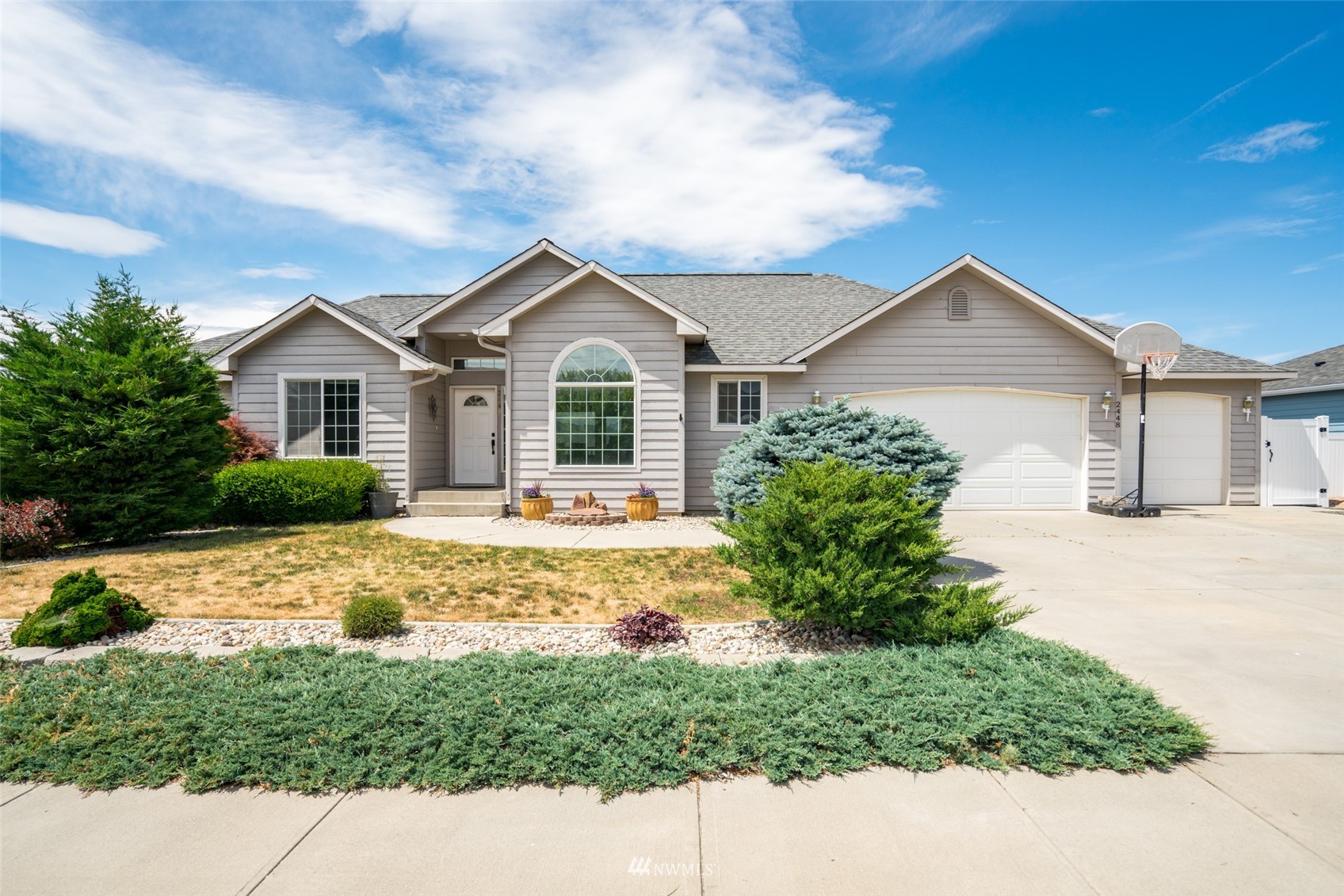 2448 Harvester Loop East Wenatchee, WA 98802 - Photo 1 of 28 a front view of a house with a garden