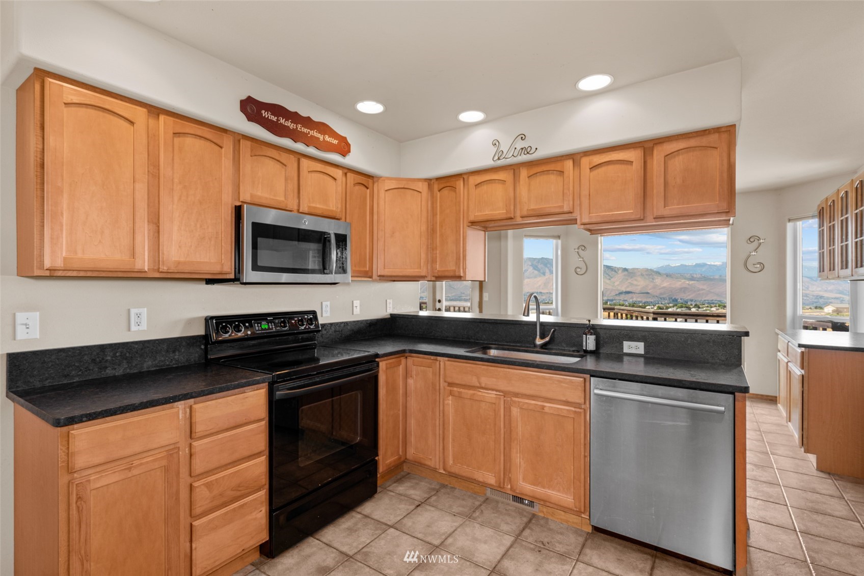 2448 Harvester Loop East Wenatchee, WA 98802 - Photo 11 of 28 a kitchen with granite countertop a stove sink microwave and cabinets