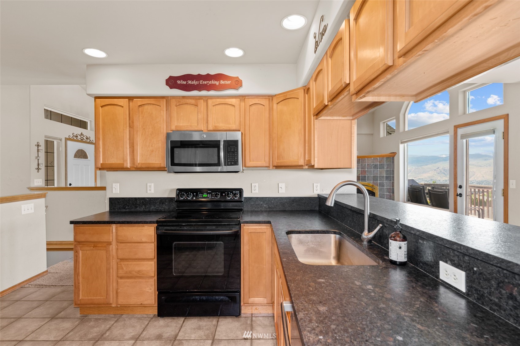 2448 Harvester Loop East Wenatchee, WA 98802 - Photo 12 of 28 a kitchen with stainless steel appliances a stove a sink and a microwave