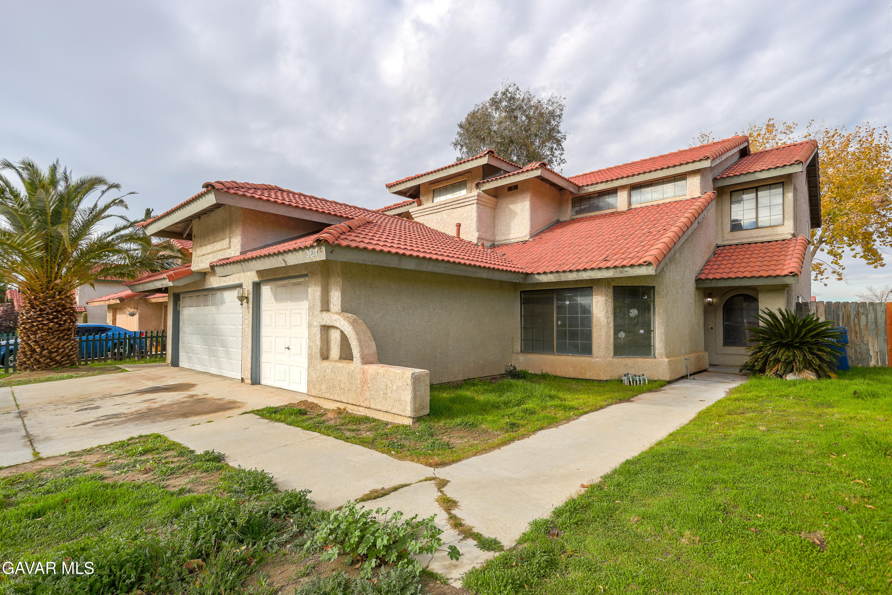 5217 East Ave R 4 Palmdale, CA 93552 - Photo 2 of 33 a front view of a house with a yard and garage
