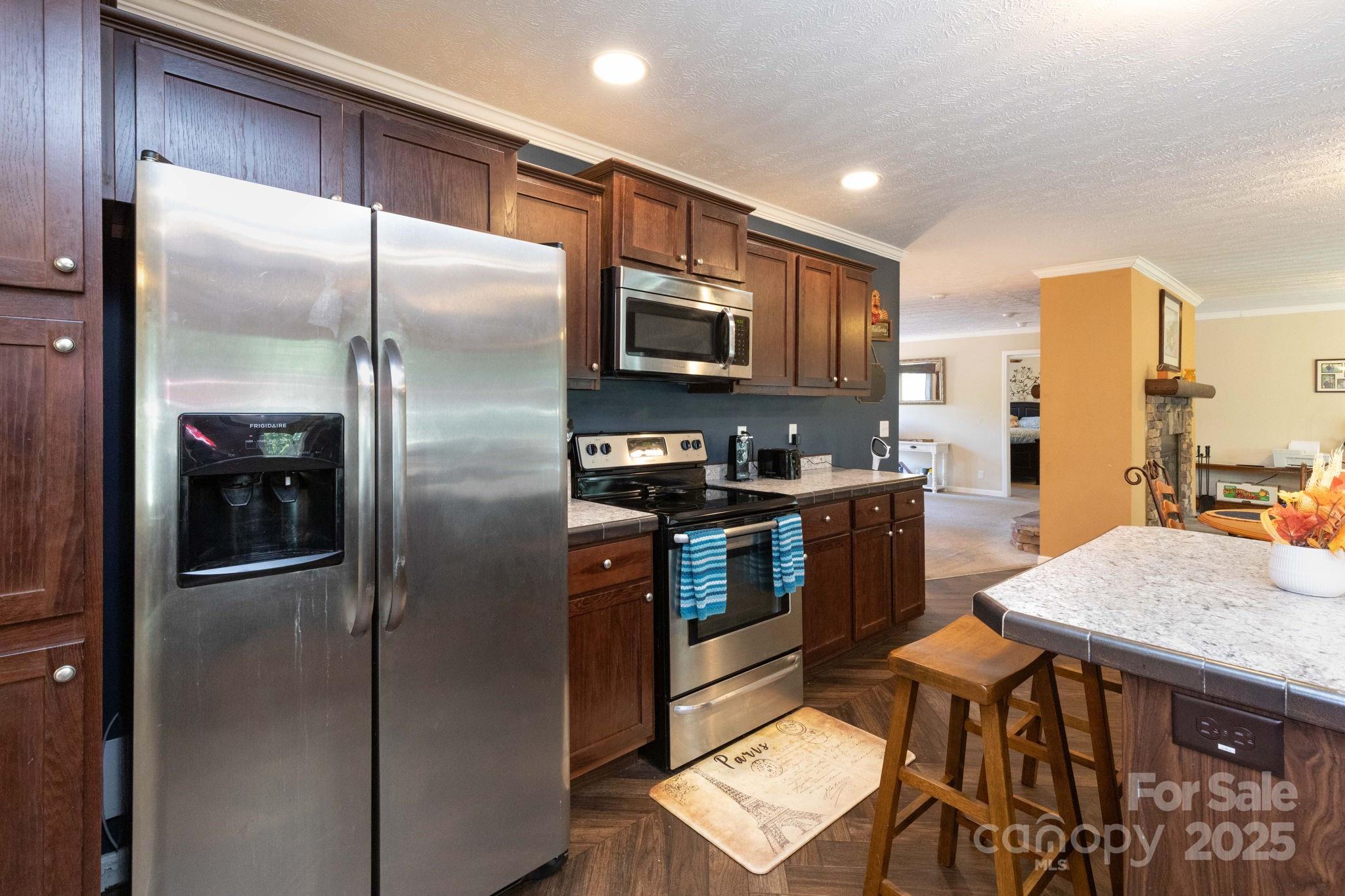 324 Lytle Cove Road Swannanoa, NC 28778 - Photo 12 of 27 a kitchen with stainless steel appliances granite countertop a refrigerator a stove and a sink with wooden floor