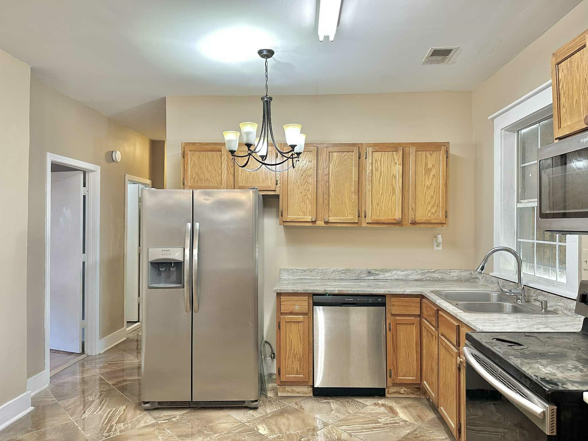 896 Orphanage Avenue Memphis, TN 38107 - Photo 7 of 17 Kitchen with stainless steel appliances, light countertops, decorative light fixtures, a chandelier, and light marble finish flooring