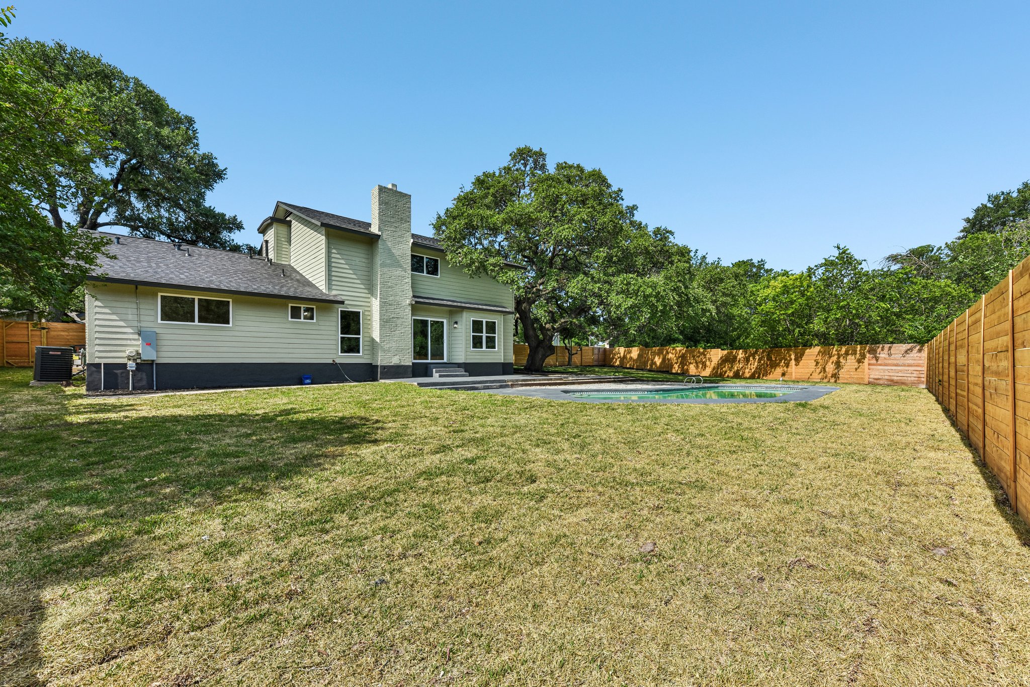 7523 Glenhill Road Austin, TX 78752 - Photo 35 of 38 A spacious yard with a shimmering pool, perfect for outdoor leisure.