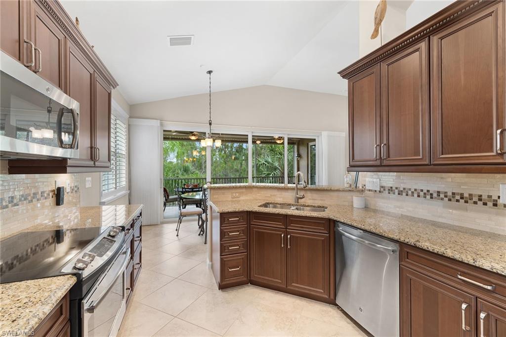 6669 Alden Woods Circle, Unit 7201 Naples, FL 34113 - Photo 12 of 28 a kitchen with a sink stove and cabinets