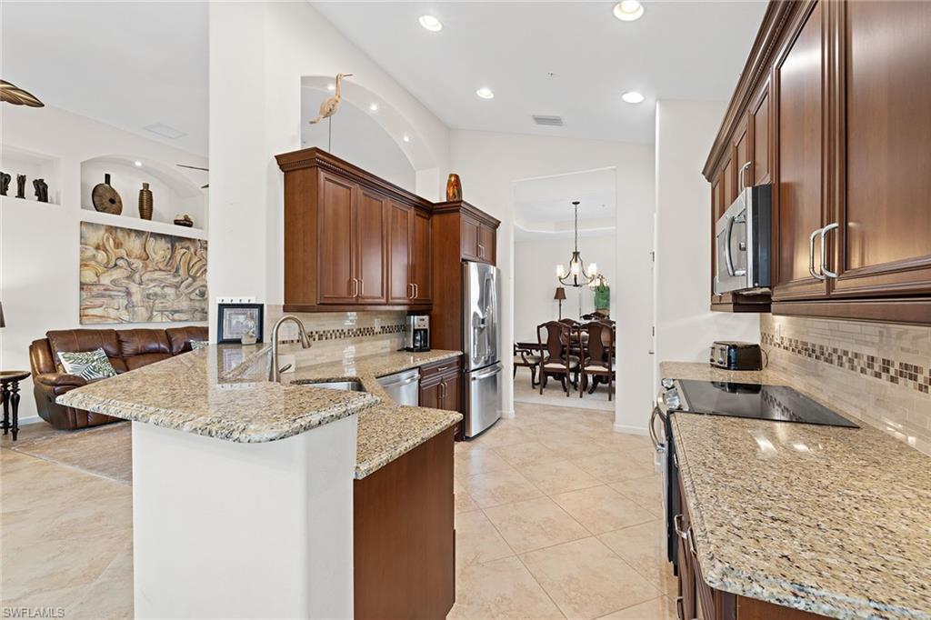 6669 Alden Woods Circle, Unit 7201 Naples, FL 34113 - Photo 13 of 28 a kitchen with sink refrigerator and cabinets