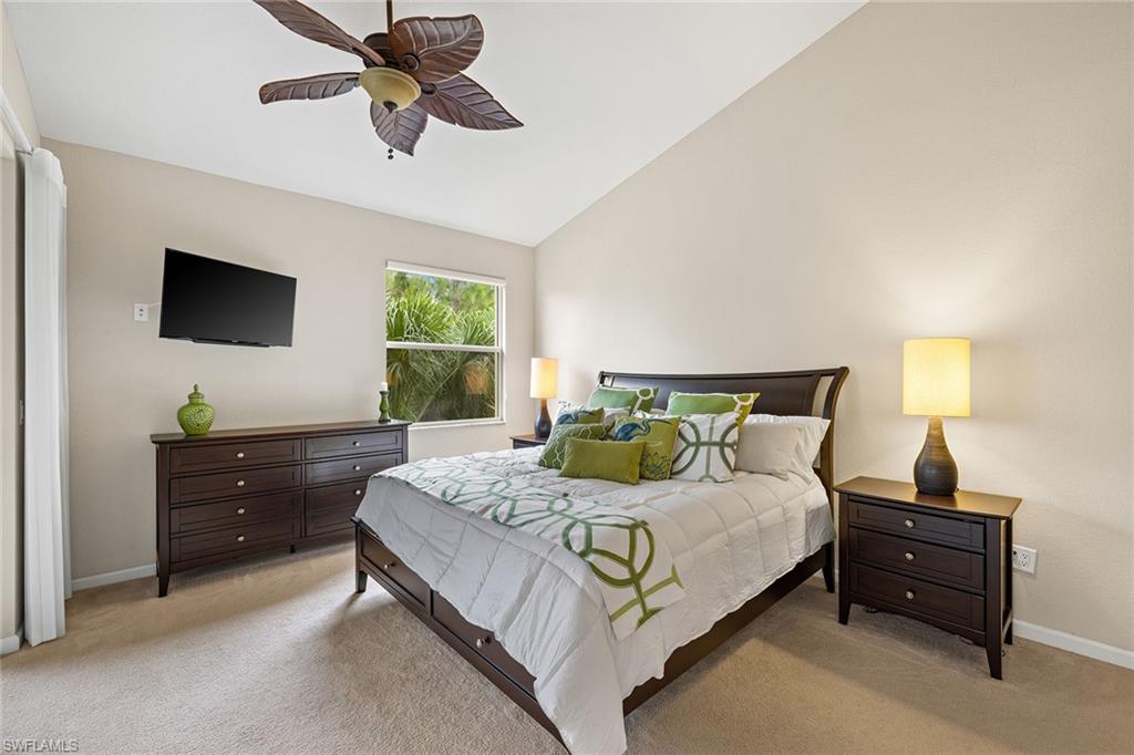 6669 Alden Woods Circle, Unit 7201 Naples, FL 34113 - Photo 16 of 28 a bedroom with a bed and a flat screen tv