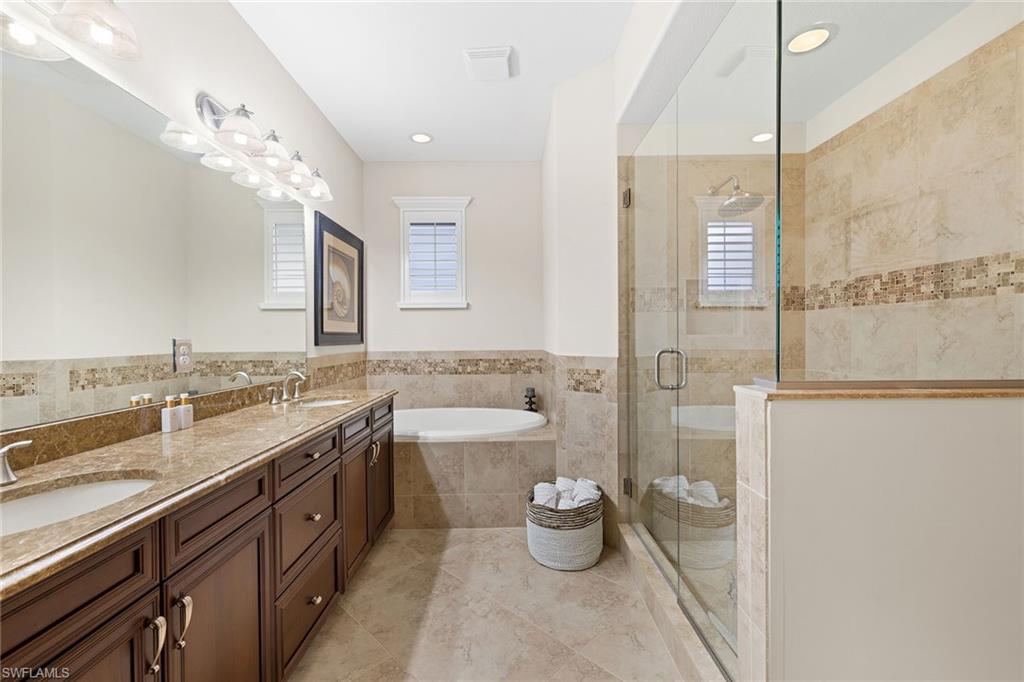 6669 Alden Woods Circle, Unit 7201 Naples, FL 34113 - Photo 19 of 28 a spacious bathroom with a double vanity sink a toilet and a shower