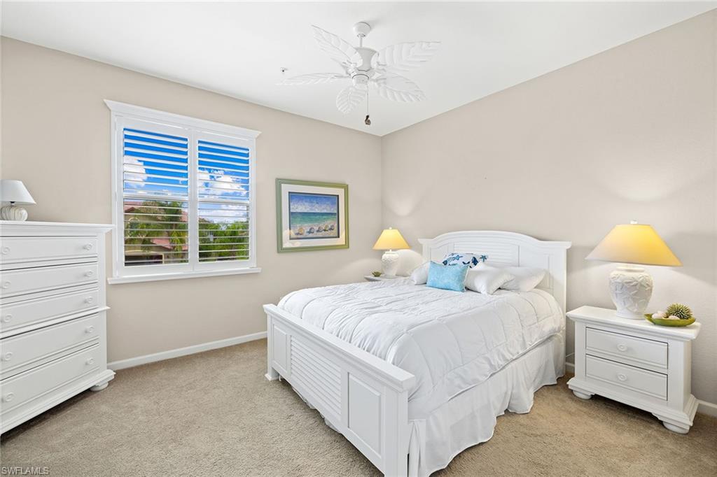 6669 Alden Woods Circle, Unit 7201 Naples, FL 34113 - Photo 20 of 28 a bedroom with a bed and a window