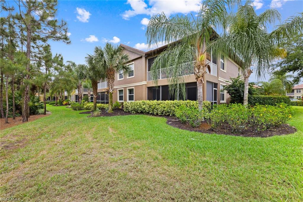 6669 Alden Woods Circle, Unit 7201 Naples, FL 34113 - Photo 27 of 28 a front view of a house with a yard