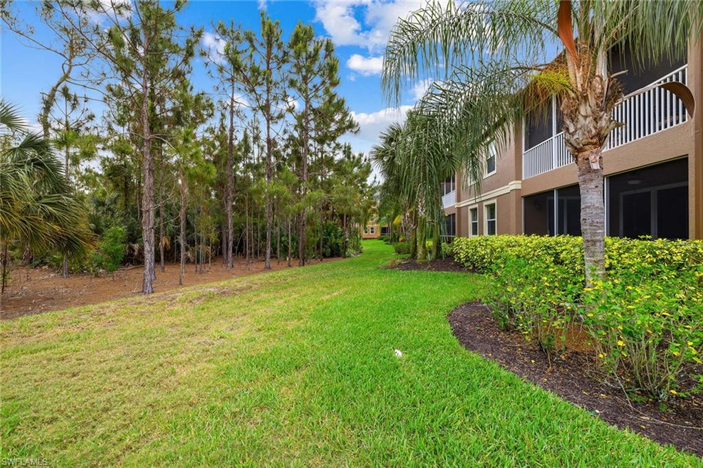 6669 Alden Woods Circle, Unit 7201 Naples, FL 34113 - Photo 28 of 28 a view of backyard with swimming pool and trees