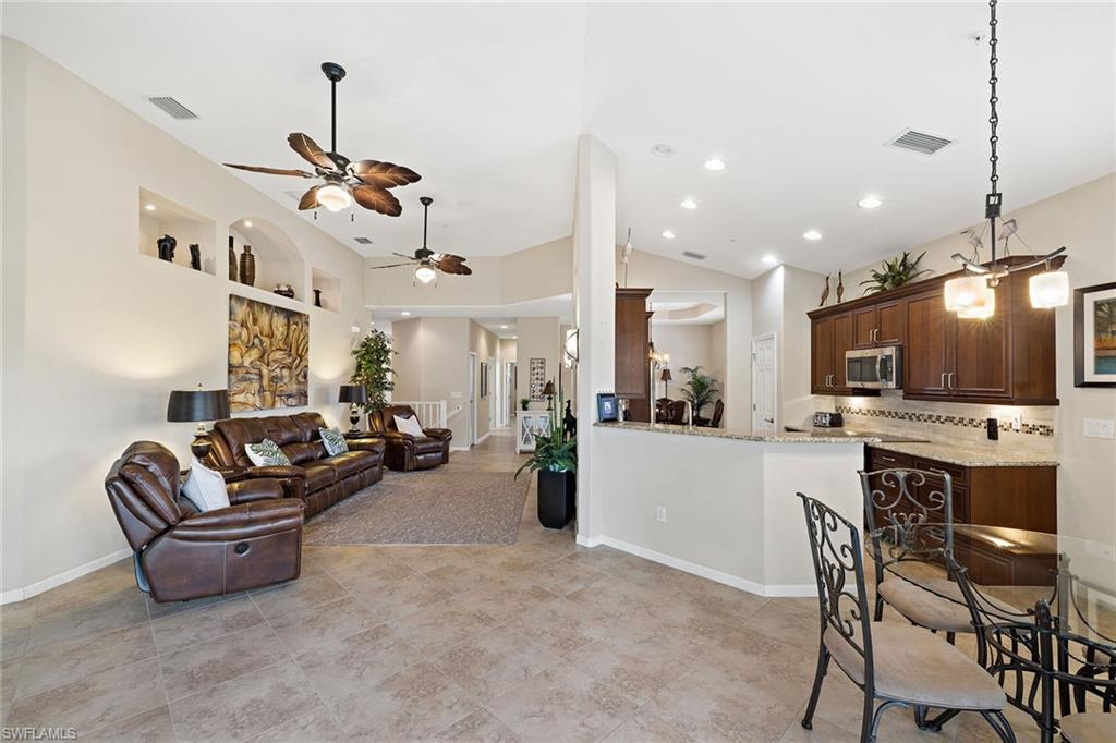 6669 Alden Woods Circle, Unit 7201 Naples, FL 34113 - Photo 6 of 28 a living room with furniture and kitchen view